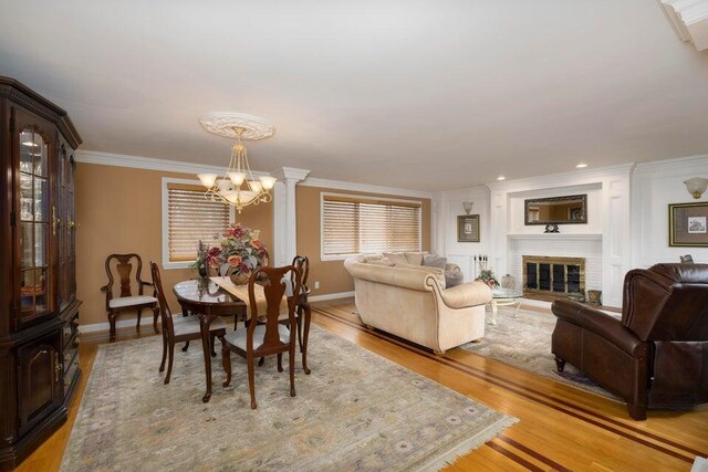 871 Bristow Rd, Independence, KY 41051 - dining area featuring a chandelier, ornamental molding, baseboards, light wood-style flooring, and a brick fireplace
