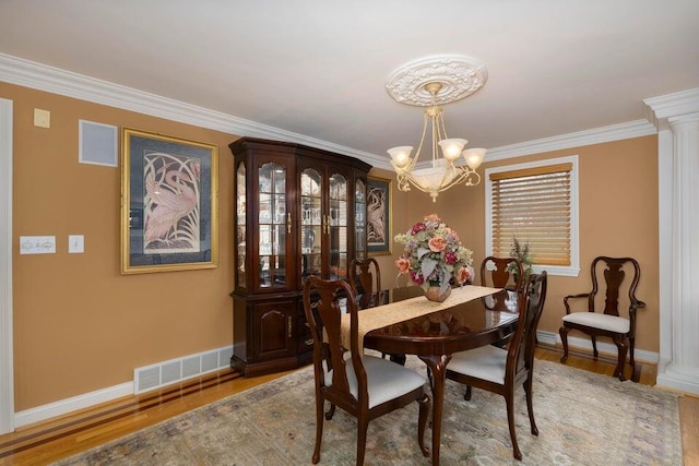 871 Bristow Rd, Independence, KY 41051 - dining space featuring a chandelier, baseboards, crown molding, wood finished floors, and decorative columns