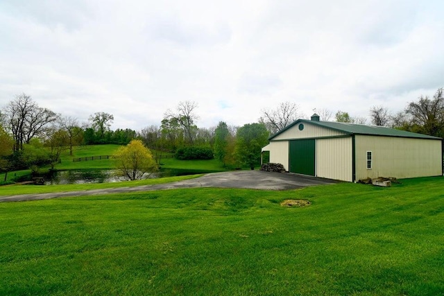 871 Bristow Rd, Independence, KY 41051 - view of green lawn with a garage, an outdoor structure, a pole building, asphalt driveway, and a water view