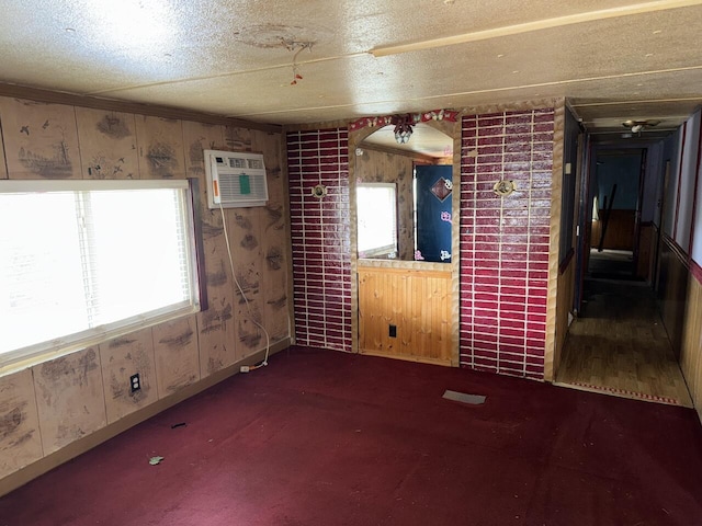 12544 Klein Rd, Morning View, KY 41063 - unfurnished room featuring healthy amount of natural light, a wall mounted AC, carpet, a textured ceiling, and wood walls