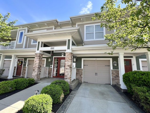 1859 Riverpointe Ct Unit 11, Dayton, KY 41074 - view of front of house featuring stone siding, a garage, and concrete driveway