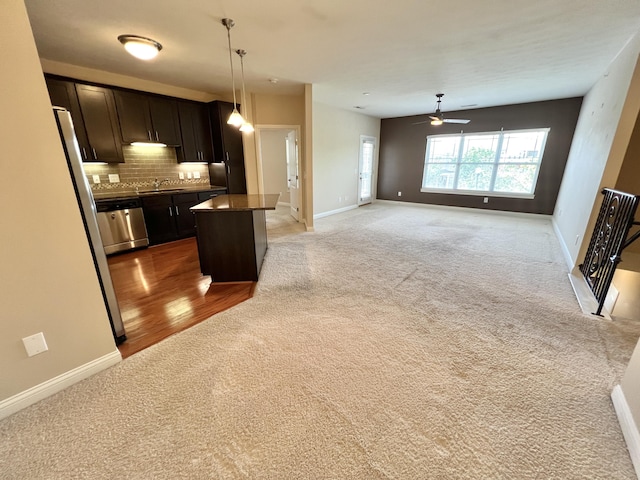 1859 Riverpointe Ct Unit 11, Dayton, KY 41074 - kitchen with light carpet, a sink, ceiling fan, dishwasher, and backsplash