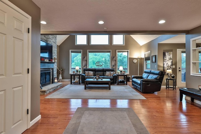 445 Elk Lake Resort Rd Unit 882, Owenton, KY 40359 - living room featuring hardwood / wood-style floors, baseboards, a fireplace, vaulted ceiling, and a textured ceiling