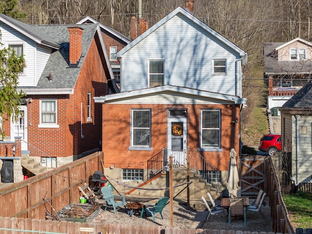 615 Highland Pike, Covington, KY 41014 - back of property with a fenced backyard, a chimney, entry steps, and brick siding