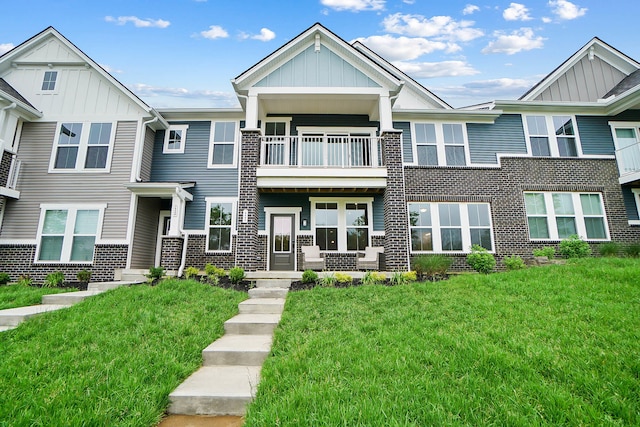 8492 Concerto Ct, Union, KY 41091 - view of front facade with a balcony, board and batten siding, a front yard, and brick siding