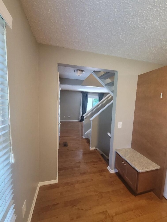218 Shaker Heights Ln, Crestview Hills, KY 41017 - hall with light wood-type flooring, a textured ceiling, and stairs