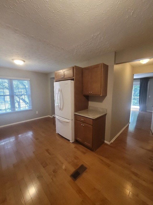 218 Shaker Heights Ln, Crestview Hills, KY 41017 - kitchen with freestanding refrigerator, wood finished floors, a textured ceiling, light countertops, and brown cabinetry