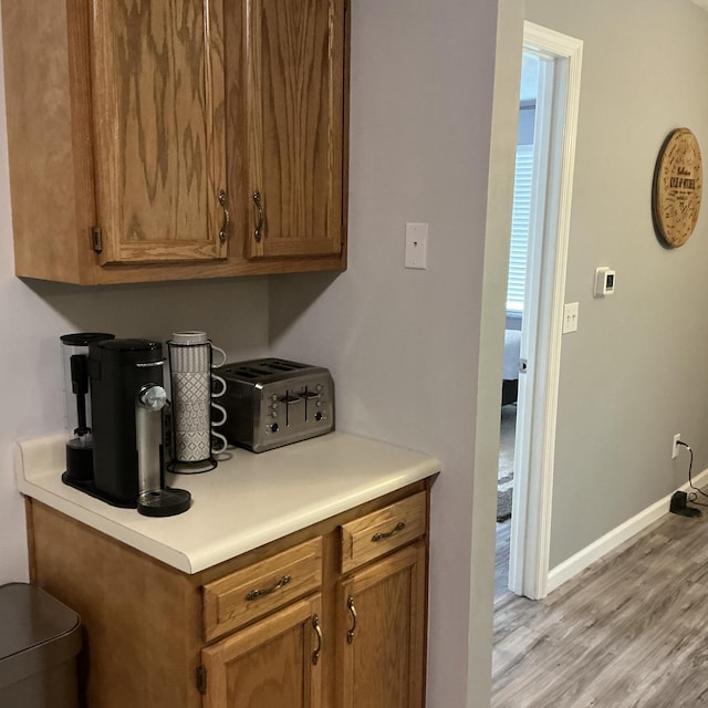 351 Deepwoods Dr, Newport, KY 41076 - kitchen featuring light wood-style floors, baseboards, brown cabinets, and light countertops