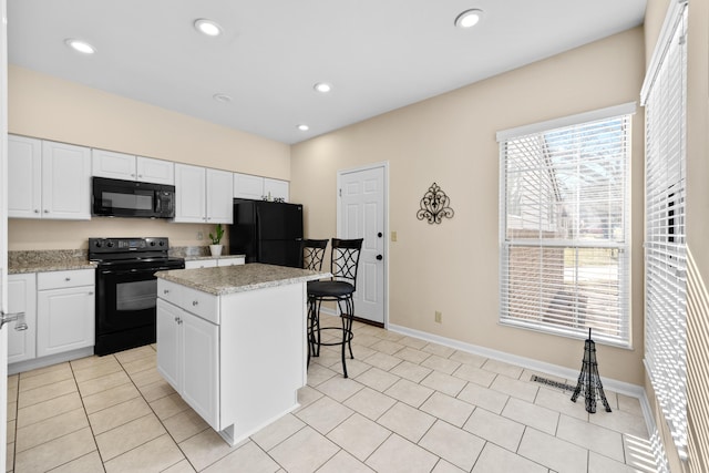 1622 Castle Hill Ln, Fort Wright, KY 41011 - kitchen with black appliances, a kitchen breakfast bar, a kitchen island, white cabinets, and recessed lighting