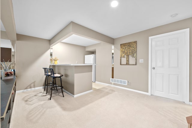 1622 Castle Hill Ln, Fort Wright, KY 41011 - kitchen featuring baseboards, light colored carpet, a kitchen breakfast bar, freestanding refrigerator, and a peninsula