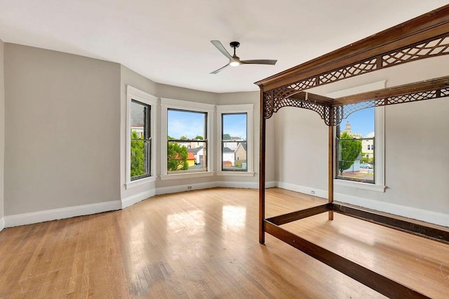 274 Ward Ave, Bellevue, KY 41073 - unfurnished bedroom with multiple windows, baseboards, wood finished floors, and ceiling fan