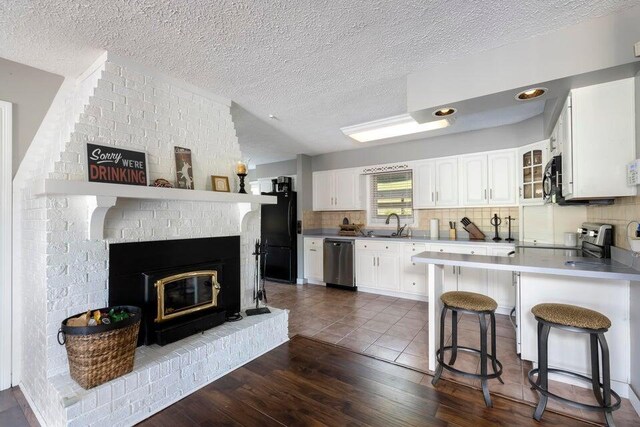 510 Jacob Dr, Williamstown, KY 41097 - kitchen with black appliances, a breakfast bar, white cabinets, dark wood finished floors, and tasteful backsplash