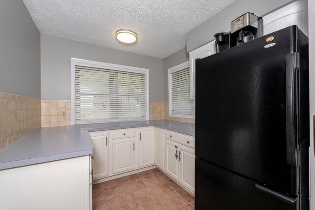 510 Jacob Dr, Williamstown, KY 41097 - kitchen with freestanding refrigerator, white cabinetry, light tile patterned flooring, backsplash, and a textured ceiling