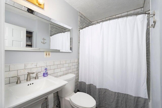 510 Jacob Dr, Williamstown, KY 41097 - bathroom featuring toilet, a textured ceiling, a sink, tile walls, and curtained shower