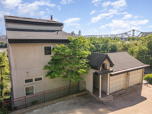 902 Vernon Pl, Covington, KY 41016 - view of home's exterior with stucco siding, roof with shingles, and a garage