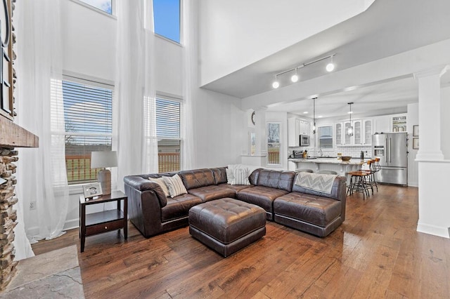 4800 Brewer Ln, Petersburg, KY 41080 - living room featuring dark wood finished floors, healthy amount of natural light, ornate columns, and a towering ceiling