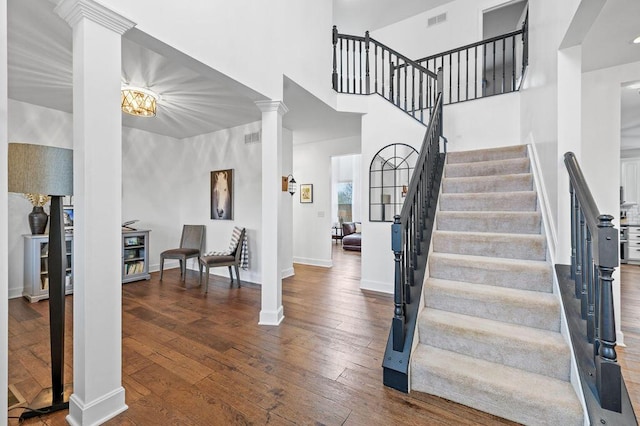 4800 Brewer Ln, Petersburg, KY 41080 - staircase featuring hardwood / wood-style floors, decorative columns, baseboards, and a towering ceiling