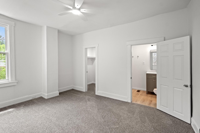 904 5th Ave, Dayton, KY 41074 - unfurnished bedroom featuring light colored carpet, a spacious closet, ensuite bathroom, baseboards, and ceiling fan