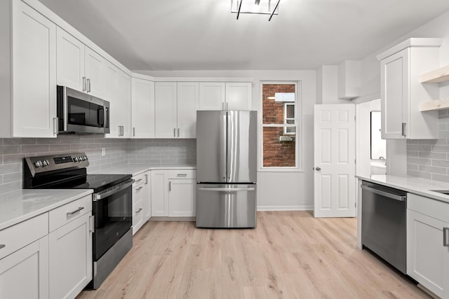 904 5th Ave, Dayton, KY 41074 - kitchen featuring stainless steel appliances, open shelves, light wood-type flooring, white cabinetry, and decorative backsplash