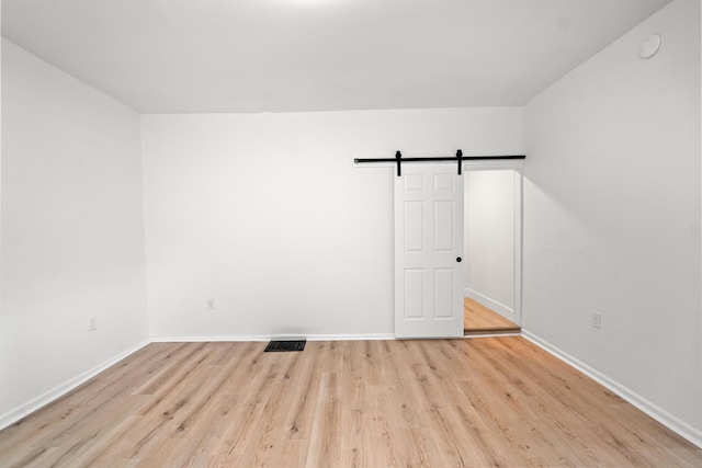 904 5th Ave, Dayton, KY 41074 - spare room featuring a barn door, light wood-style floors, baseboards, and a smoke detector