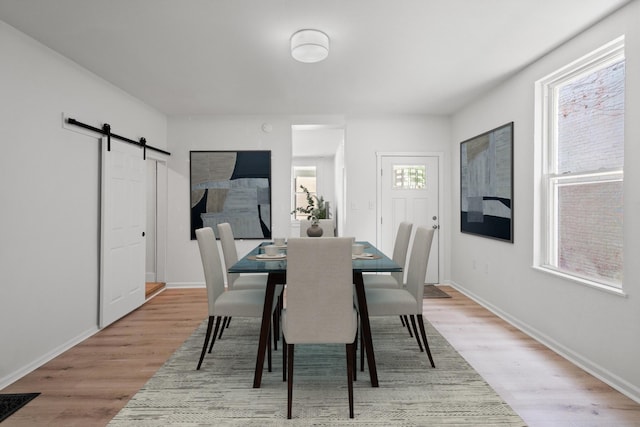 904 5th Ave, Dayton, KY 41074 - dining space featuring light wood-style flooring, a barn door, and baseboards