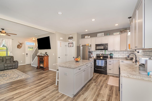 1500 Heathen Ridge Rd, Crittenden, KY 41030 - kitchen with black appliances, open floor plan, a sink, a kitchen island, and light wood-type flooring