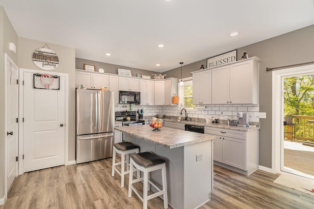 1500 Heathen Ridge Rd, Crittenden, KY 41030 - kitchen with black appliances, decorative backsplash, light wood-style flooring, a center island, and plenty of natural light