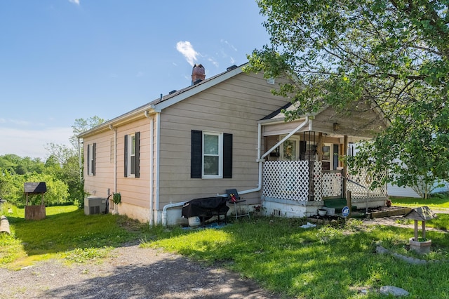 29 Locust St, Walton, KY 41094 - back of property featuring covered porch, a chimney, a yard, and cooling unit
