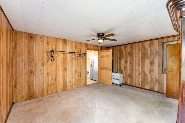 5489 Bridgeville Rd, Brooksville, KY 41004 - unfurnished bedroom featuring stainless steel refrigerator with ice dispenser, wood walls, light colored carpet, and a ceiling fan