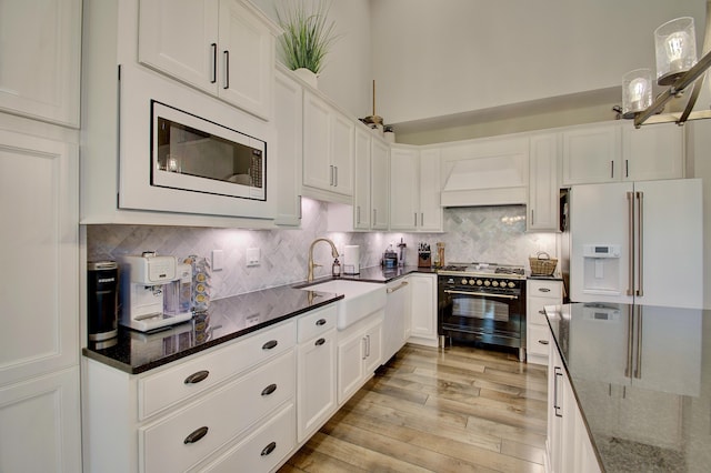 827 Iva Del Ct, Crescent Springs, KY 41017 - kitchen featuring high end stove, white refrigerator with ice dispenser, premium range hood, built in microwave, and a sink
