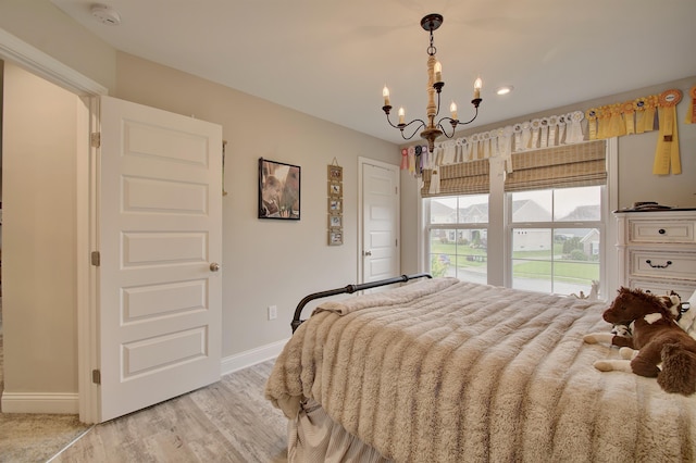 827 Iva Del Ct, Crescent Springs, KY 41017 - bedroom with a chandelier, baseboards, and light wood-style flooring