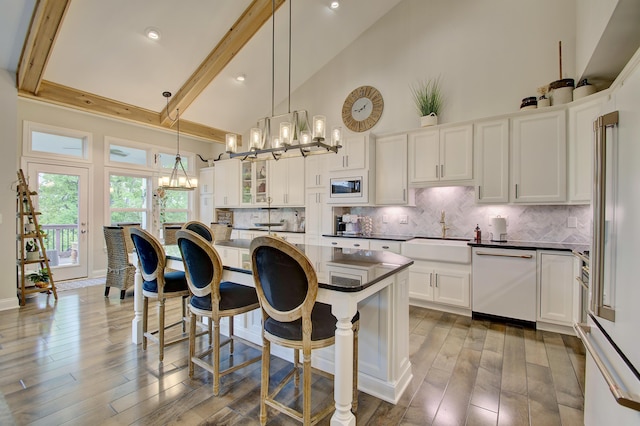 827 Iva Del Ct, Crescent Springs, KY 41017 - kitchen with white appliances, a sink, dark countertops, high vaulted ceiling, and a breakfast bar