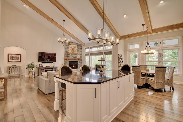 827 Iva Del Ct, Crescent Springs, KY 41017 - kitchen featuring a chandelier, high vaulted ceiling, beam ceiling, light wood-style floors, and a stone fireplace