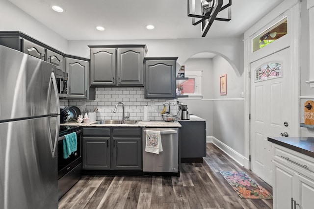 203 E Southern Ave, Covington, KY 41015 - kitchen featuring stainless steel appliances, gray cabinets, a sink, tasteful backsplash, and dark wood finished floors
