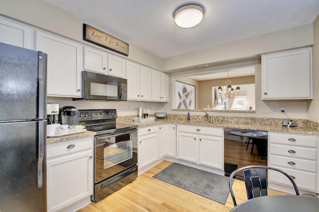 208 Misty Cove Way, Highland Heights, KY 41076 - kitchen featuring black appliances, light wood-style flooring, a chandelier, white cabinets, and a textured ceiling