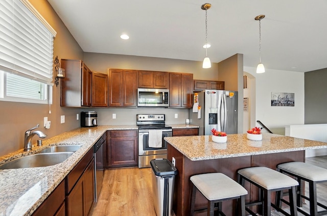 1344 Wilshire Ct, Union, KY 41091 - kitchen featuring stainless steel appliances, a sink, a breakfast bar, light wood-type flooring, and a kitchen island