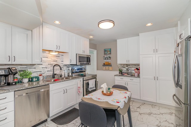 10 Juarez Cir, Covington, KY 41017 - kitchen with appliances with stainless steel finishes, a sink, backsplash, light marble finish floors, and white cabinetry