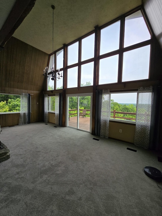 438 Ky Highway 455, Sparta, KY 41086 - unfurnished living room with high vaulted ceiling, a chandelier, carpet, wood walls, and beam ceiling