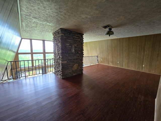 438 Ky Highway 455, Sparta, KY 41086 - unfurnished living room featuring wood finished floors, a textured ceiling, baseboards, and wood walls