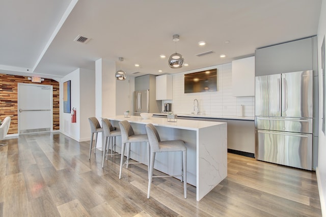 120 Main St Unit 205, Newport, KY 41071 - kitchen with freestanding refrigerator, a kitchen bar, modern cabinets, light countertops, and recessed lighting