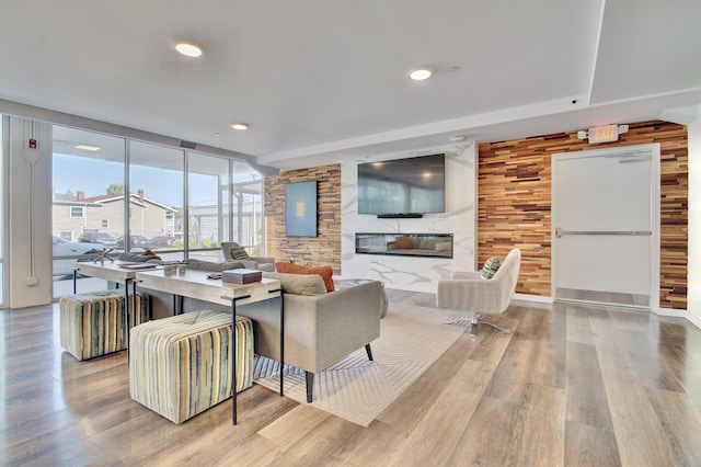 120 Main St Unit 205, Newport, KY 41071 - living room featuring wood finished floors, a wall of windows, a premium fireplace, and recessed lighting