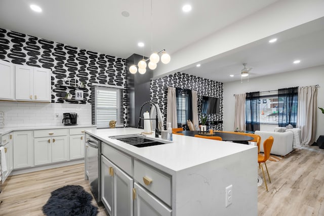 213 8th Ave, Dayton, KY 41074 - kitchen featuring a sink, light countertops, backsplash, a center island with sink, and open floor plan