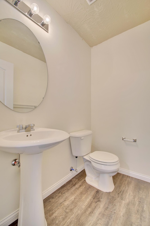 609 Crosswinds Pointe Ct, Walton, KY 41094 - half bath featuring wood finished floors, toilet, baseboards, a sink, and a textured ceiling