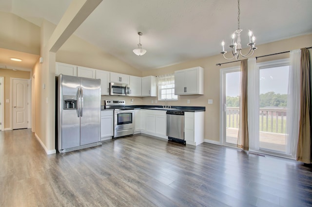 609 Crosswinds Pointe Ct, Walton, KY 41094 - kitchen with appliances with stainless steel finishes, dark countertops, a chandelier, wood finished floors, and lofted ceiling