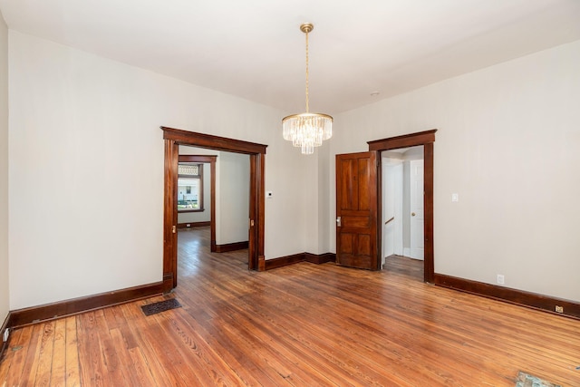 436 Elm St, Ludlow, KY 41016 - empty room with light wood-style floors, a chandelier, and baseboards