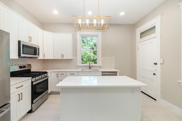 436 Elm St, Ludlow, KY 41016 - kitchen with appliances with stainless steel finishes, a sink, a center island, backsplash, and light wood finished floors