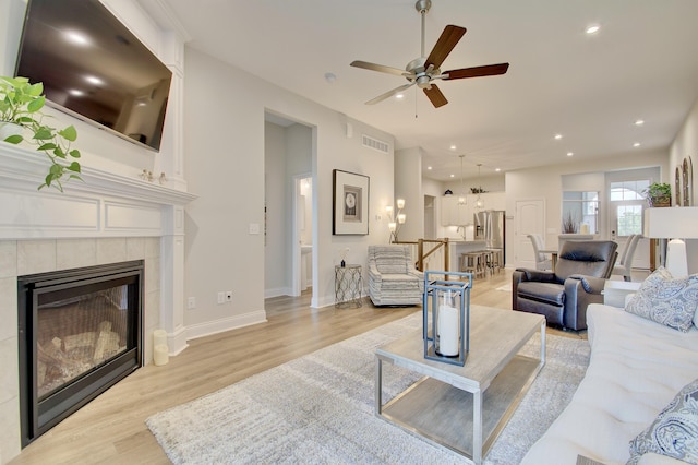 3942 Brunswick Ct, Erlanger, KY 41018 - living room featuring light wood finished floors, a ceiling fan, a tile fireplace, recessed lighting, and baseboards
