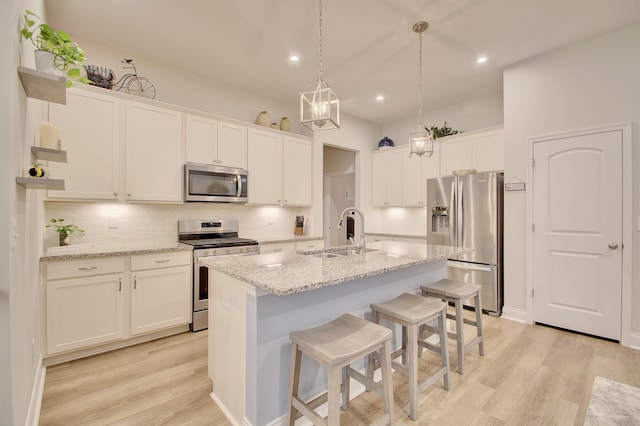 3942 Brunswick Ct, Erlanger, KY 41018 - kitchen featuring stainless steel appliances, a sink, backsplash, light wood-style floors, and a center island with sink
