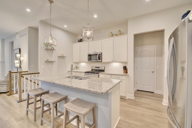 3942 Brunswick Ct, Erlanger, KY 41018 - kitchen with stainless steel appliances, a sink, light wood-style flooring, backsplash, and white cabinets
