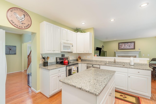 4049 Sherbourne Dr, Independence, KY 41051 - kitchen featuring appliances with stainless steel finishes, a sink, light wood finished floors, a kitchen island, and recessed lighting